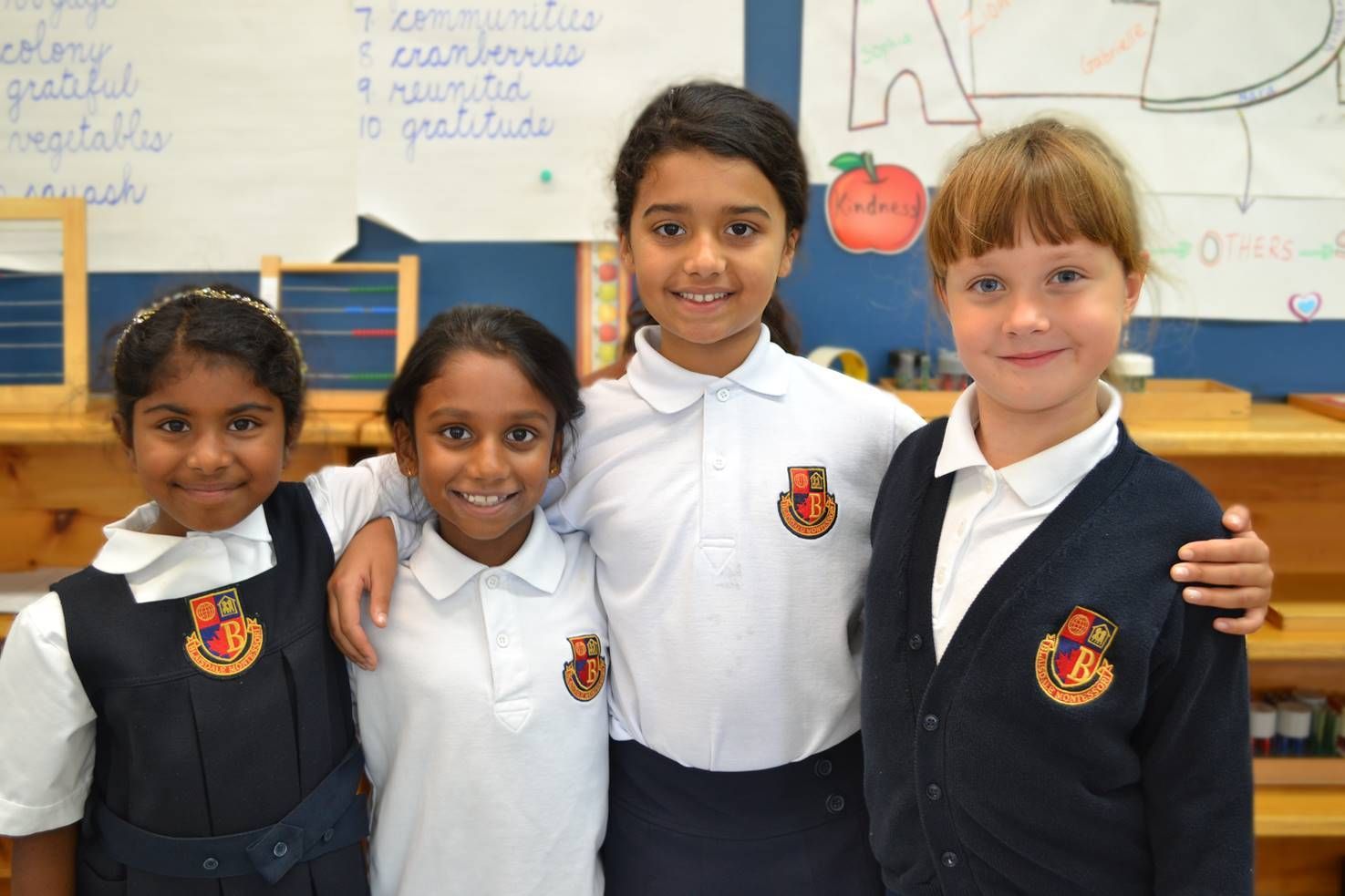 A group of young girls posing for a picture in a classroom