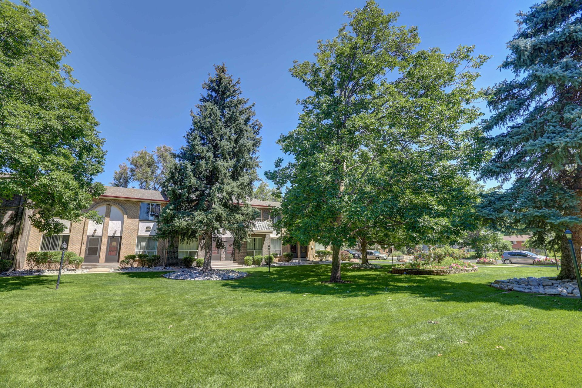 A large lawn with trees in front of a building.