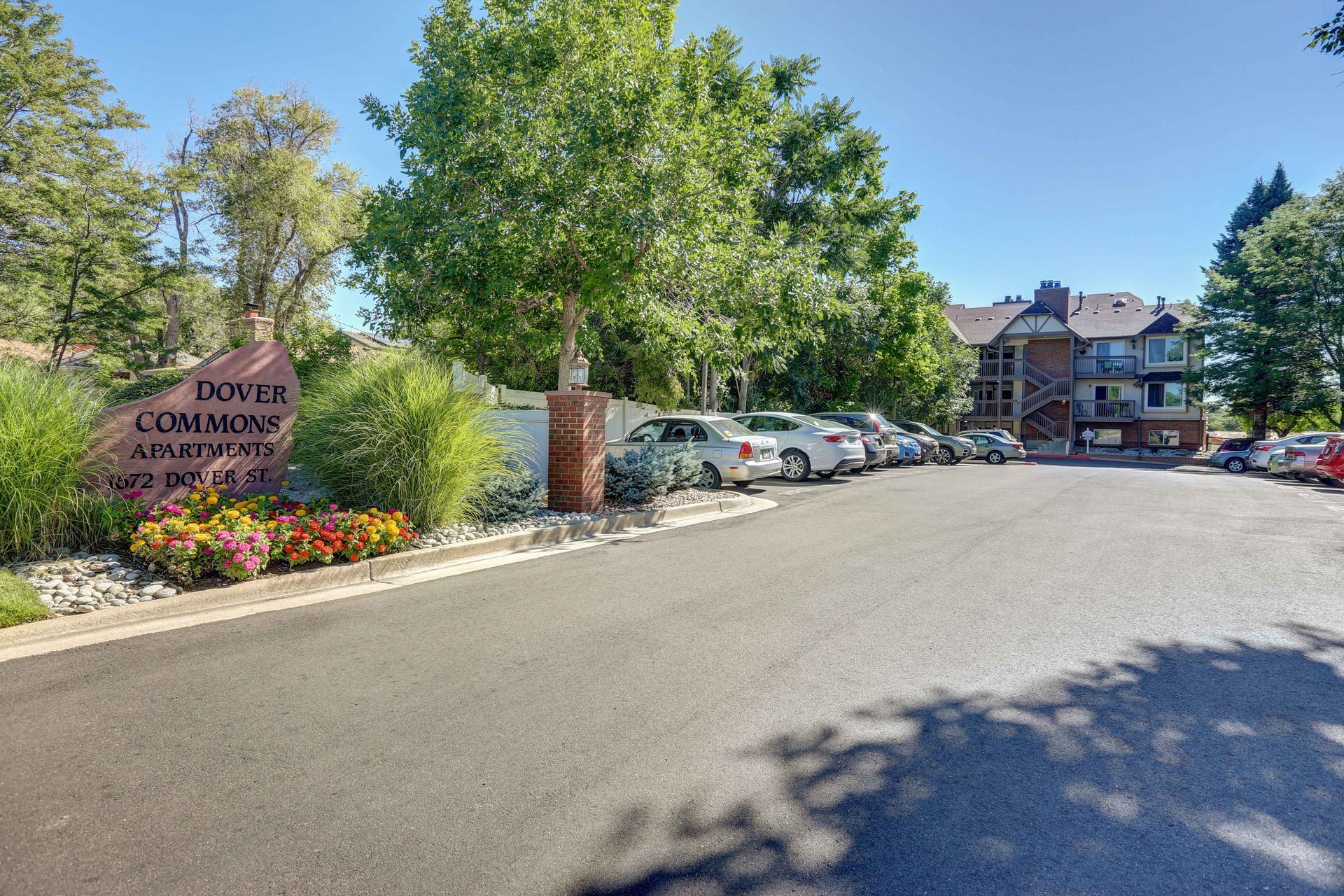 A parking lot with cars parked in front of a building.