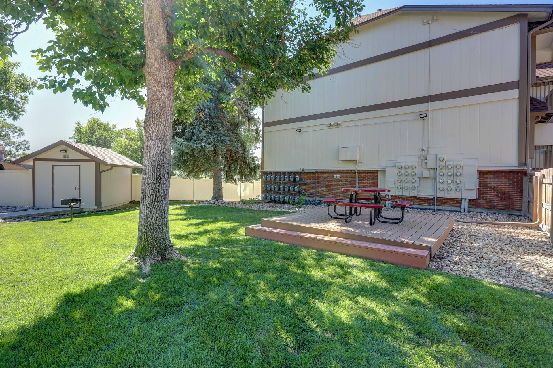 There is a picnic table in the grass in front of a building.