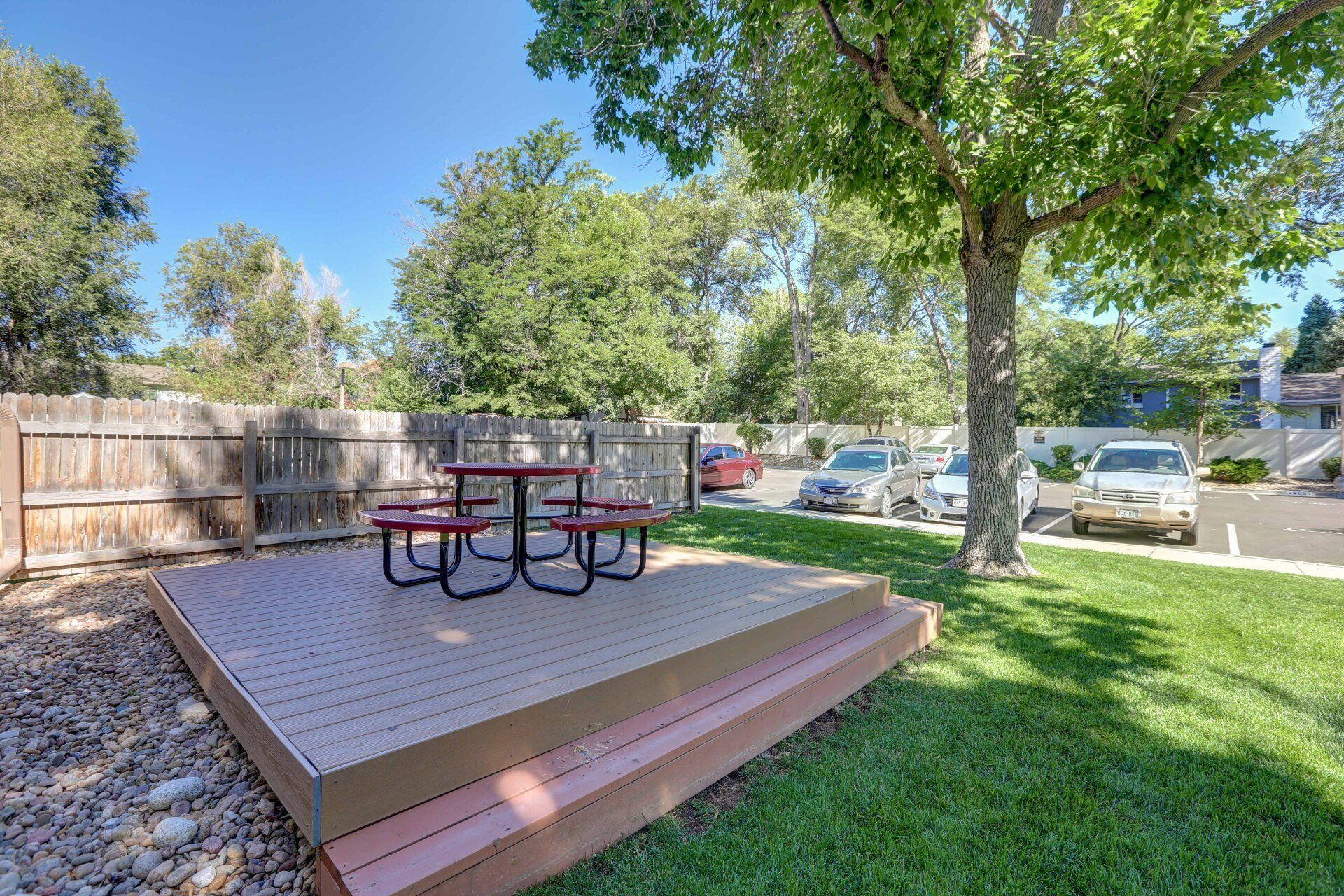 A picnic table is sitting on top of a wooden deck in a park.
