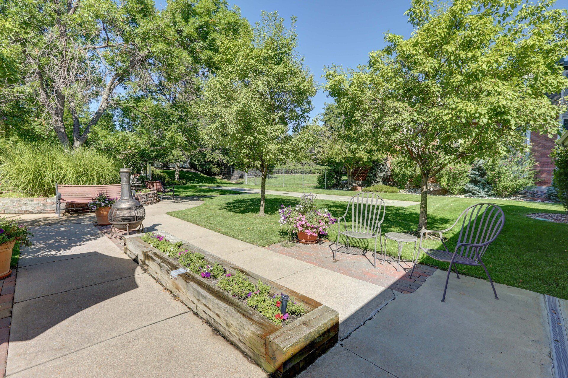There is a planter with flowers in it in the middle of the yard.