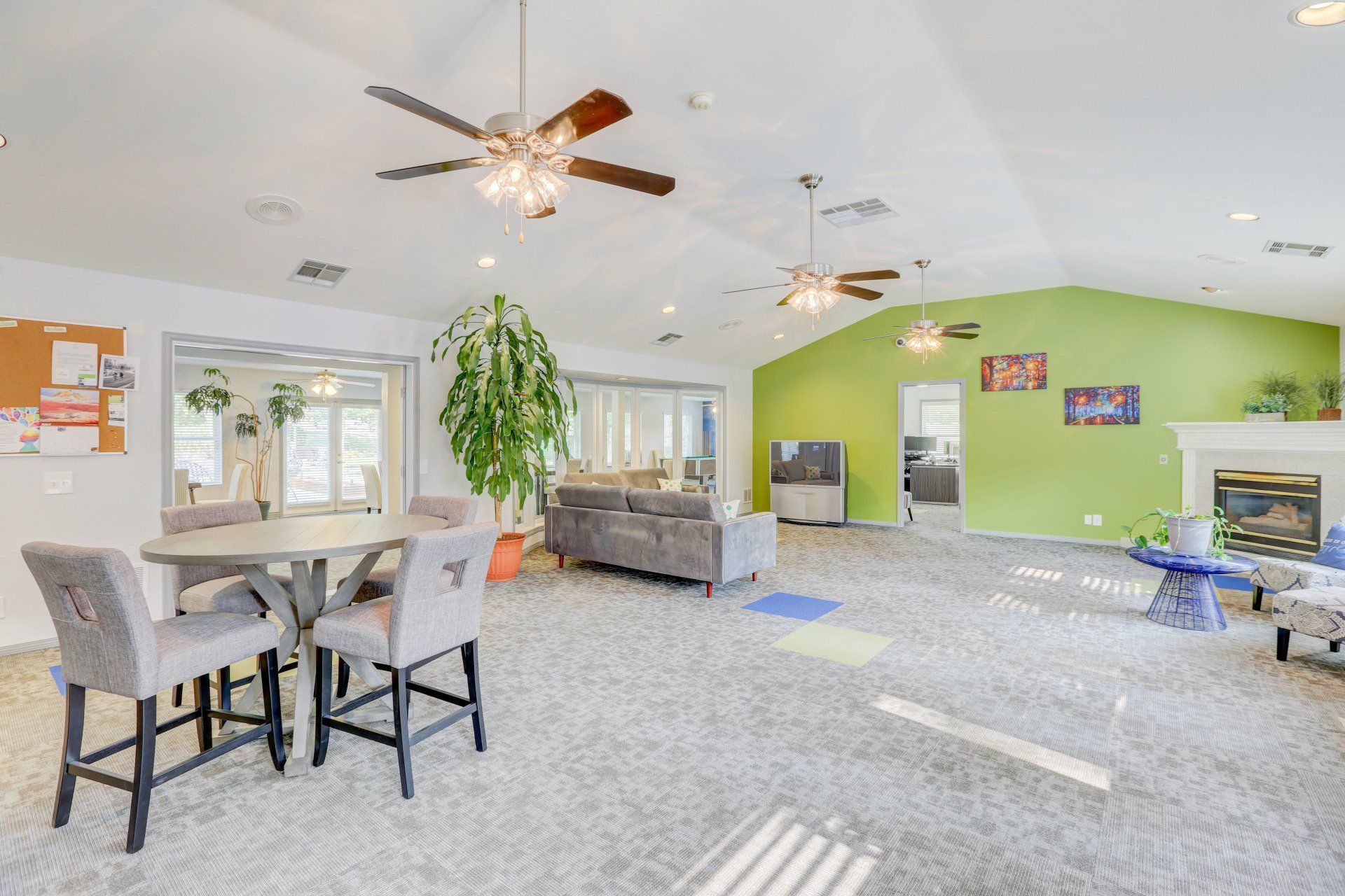A living room with a table and chairs and a ceiling fan.