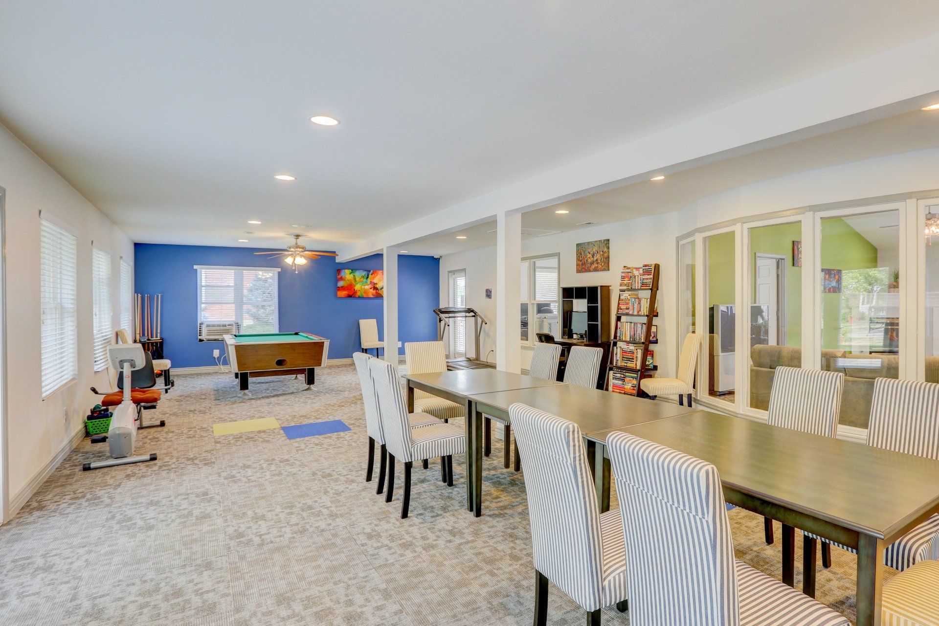 A large room with tables and chairs and a pool table.