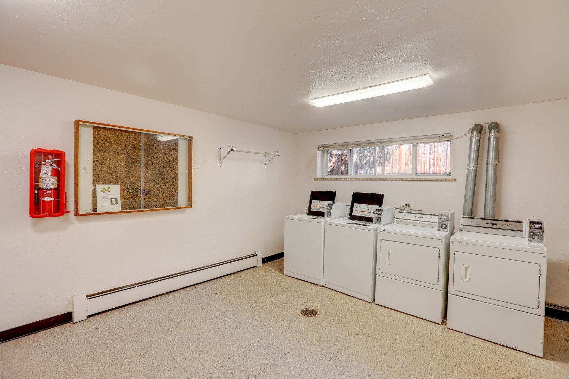 A laundry room with a washer and dryer and a fire extinguisher.