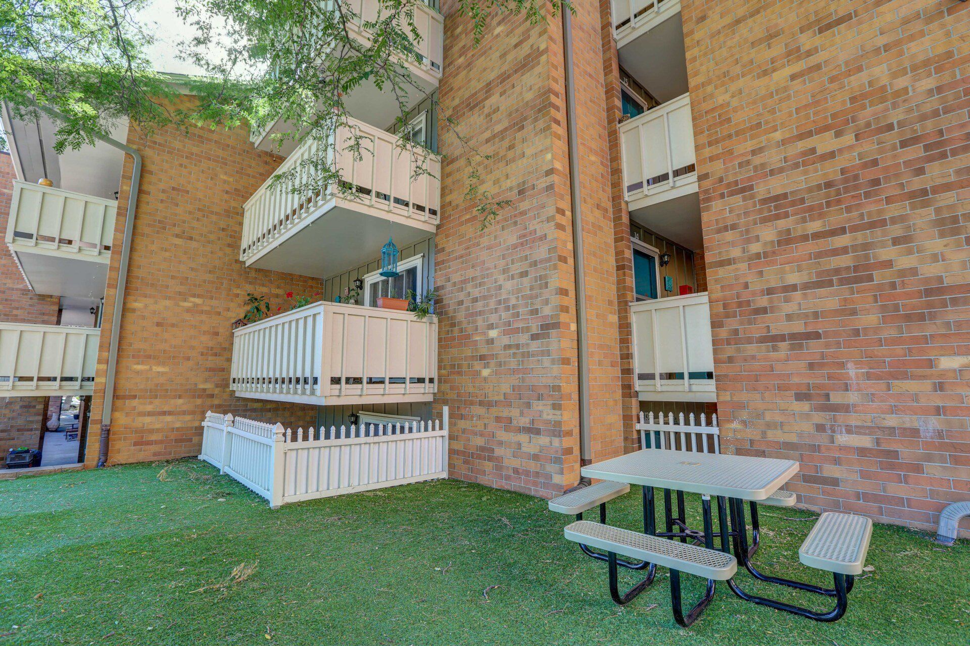 A picnic table is sitting in front of a brick building.