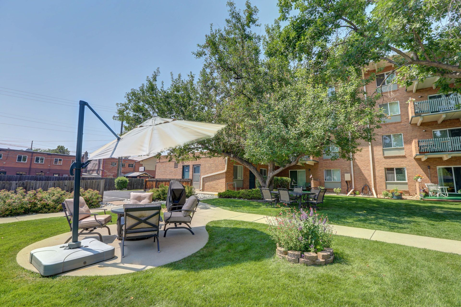 A patio area with a table and chairs under an umbrella in front of a building.