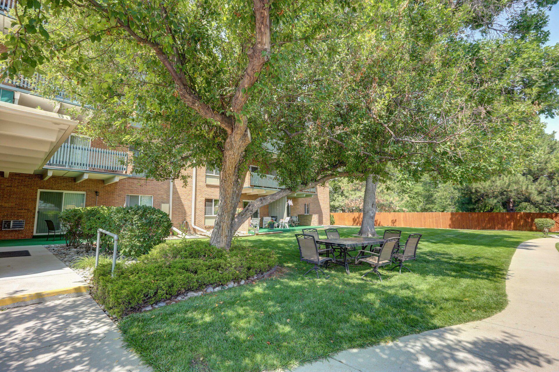 There is a table and chairs in the backyard of a building.