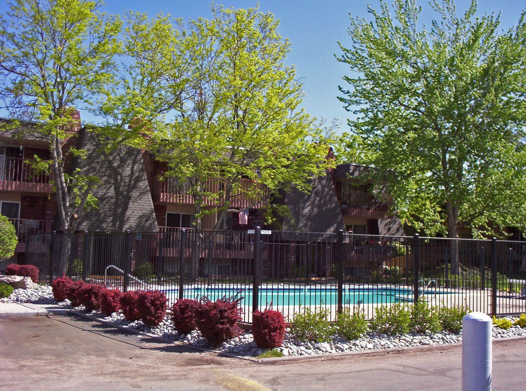 A fence surrounds a swimming pool in front of a building