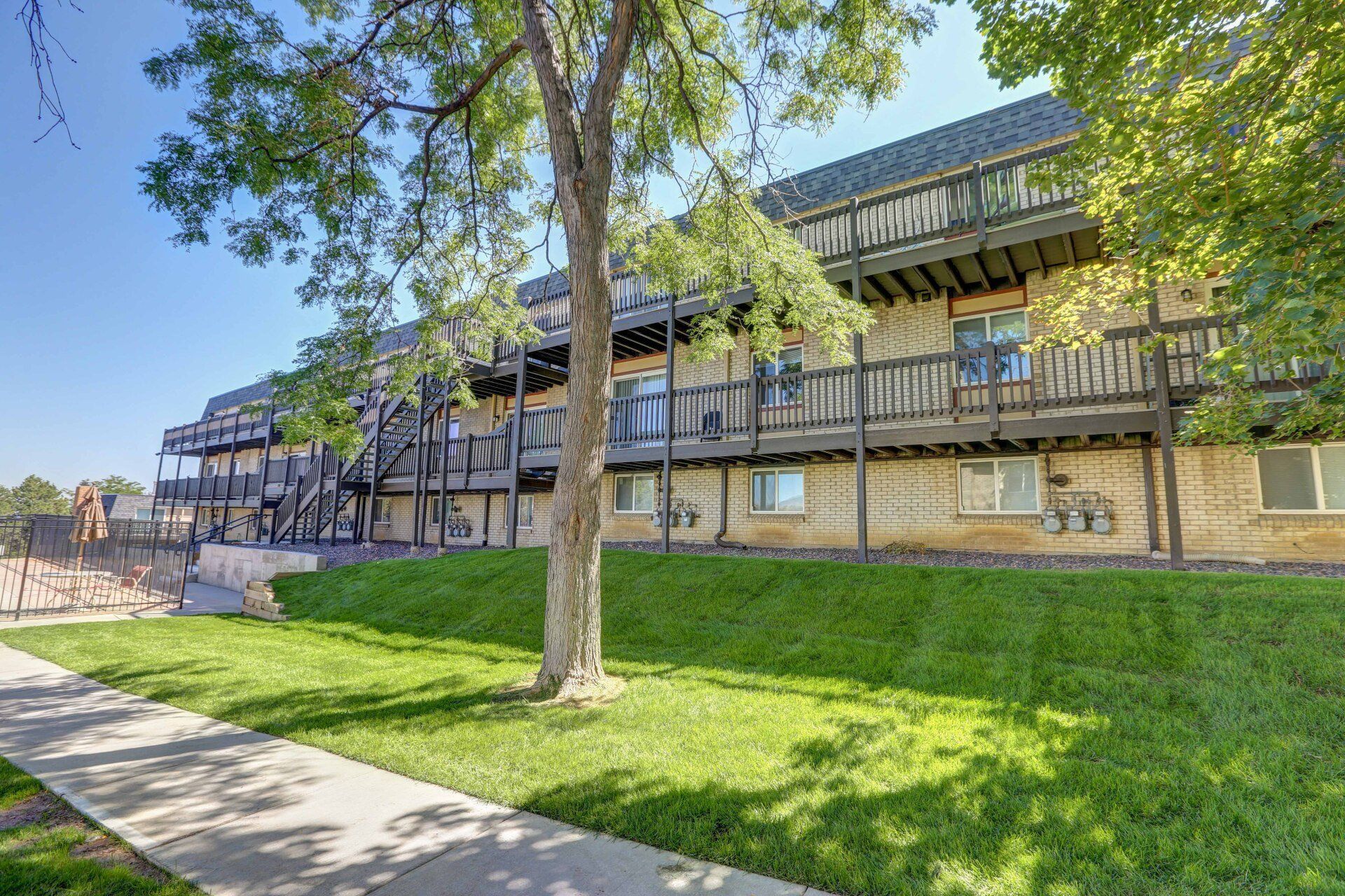 A large apartment building with a tree in front of it.