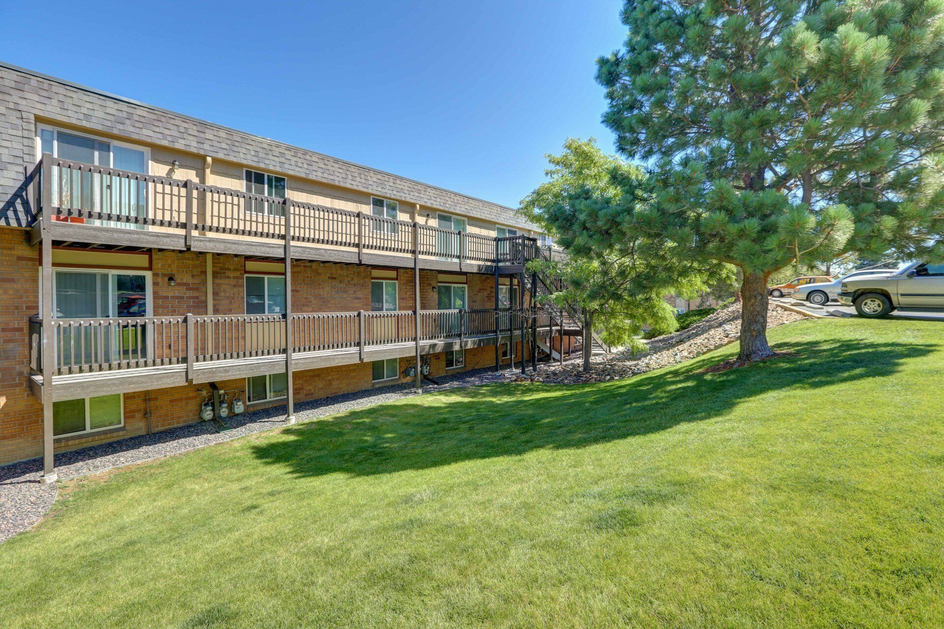 A large apartment building with a lot of balconies and a car parked in front of it.