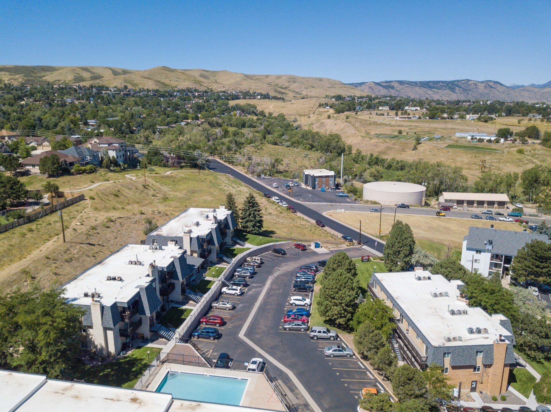 An aerial view of a building with a pool in front of it.