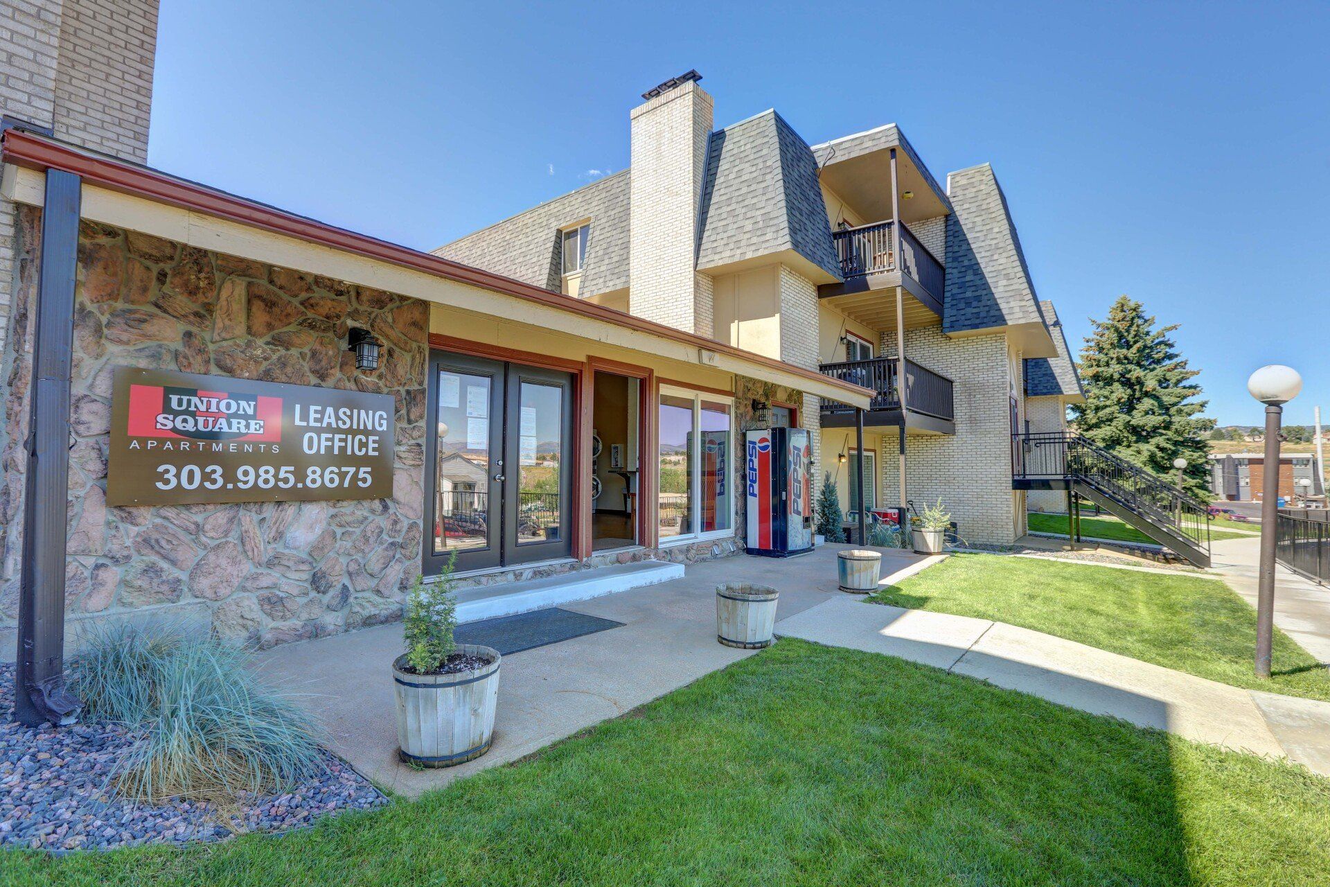 A large apartment building with a lot of windows and a vending machine in front of it.
