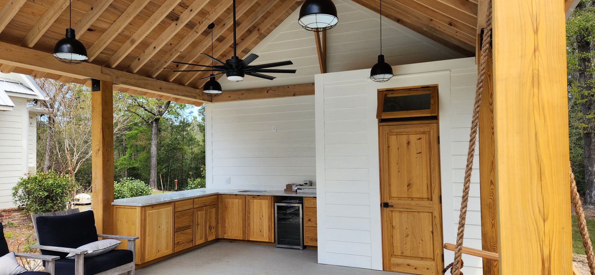 There is a porch with a swing and a ceiling fan.