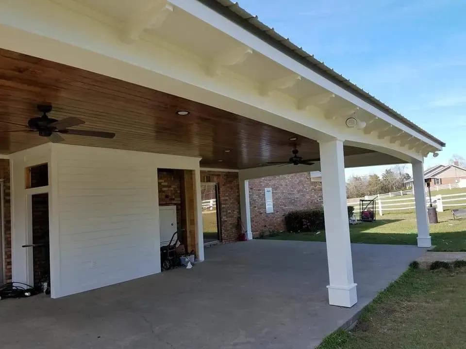 A white house with a covered porch and a ceiling fan.