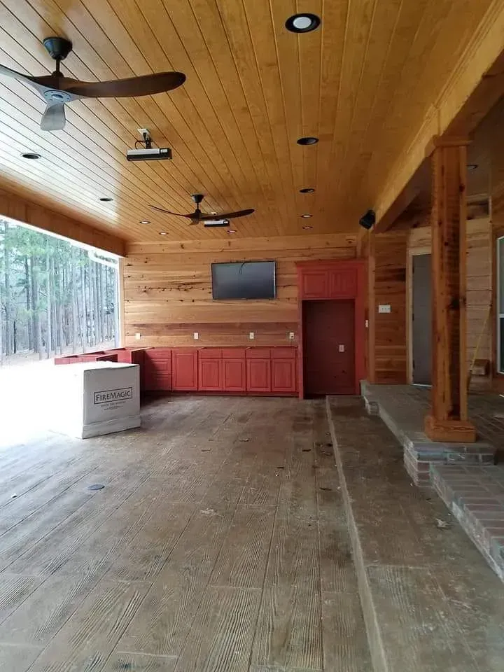 A large room with a ceiling fan and a television on the wall.