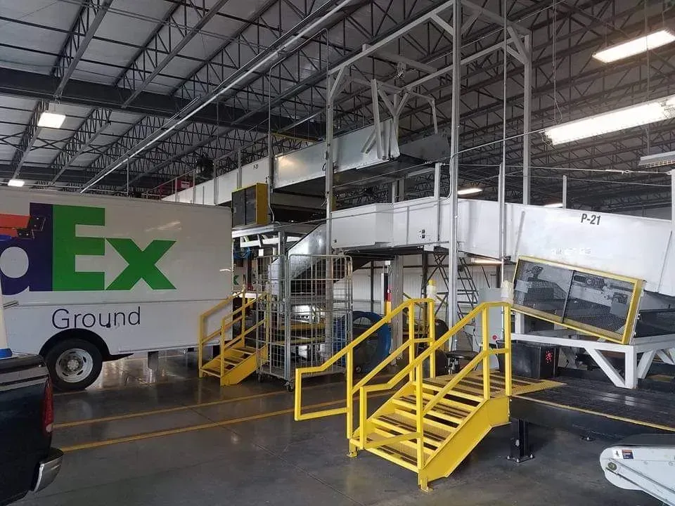 A fedex ground truck is parked in a warehouse