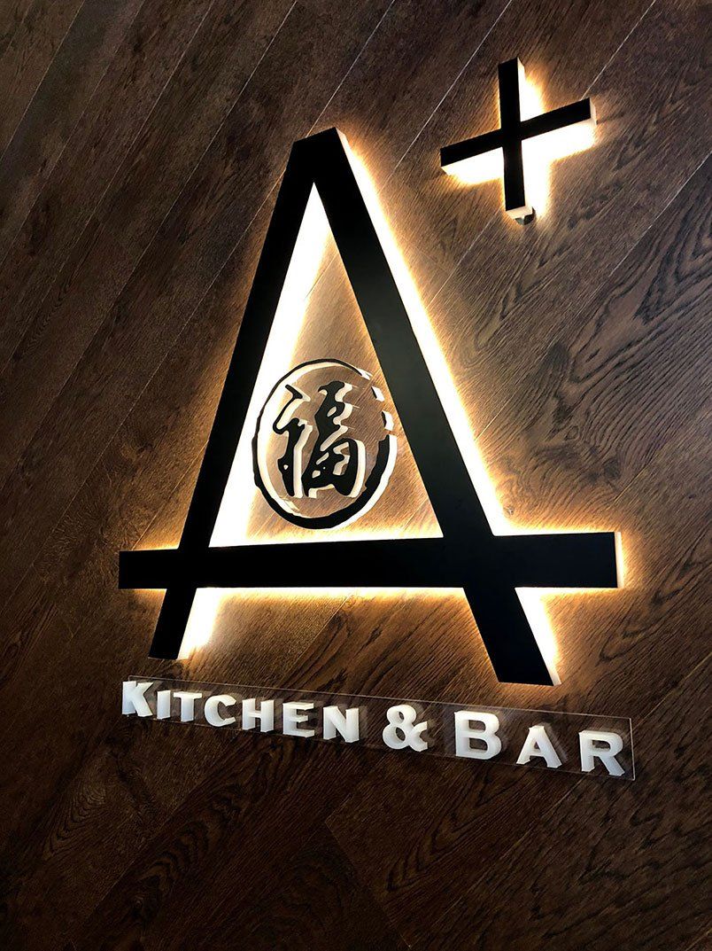 A Plus Logo On Wood Wall — Signage In Acacia Ridge, QLD