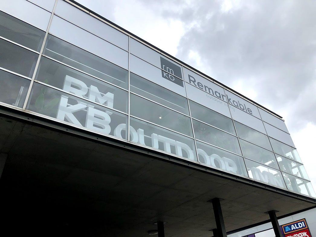 A Logo Signage Behind Glass Panels — Signage In Acacia Ridge, QLD