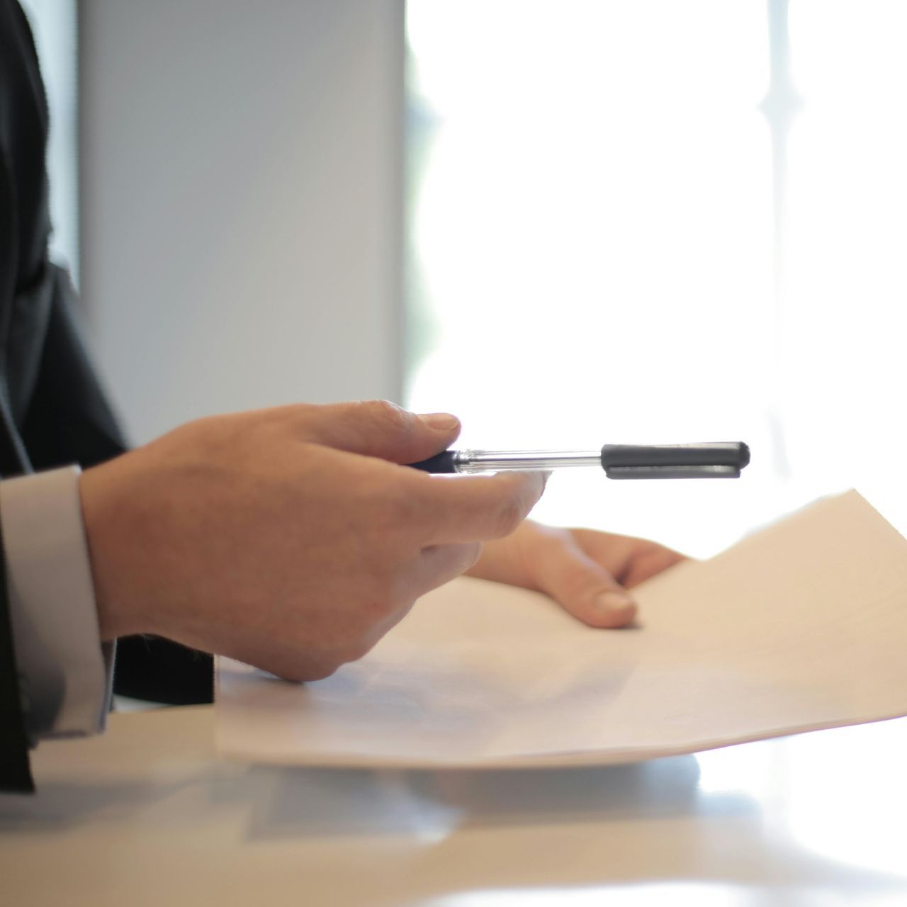 A person holding a pen over a piece of paper
