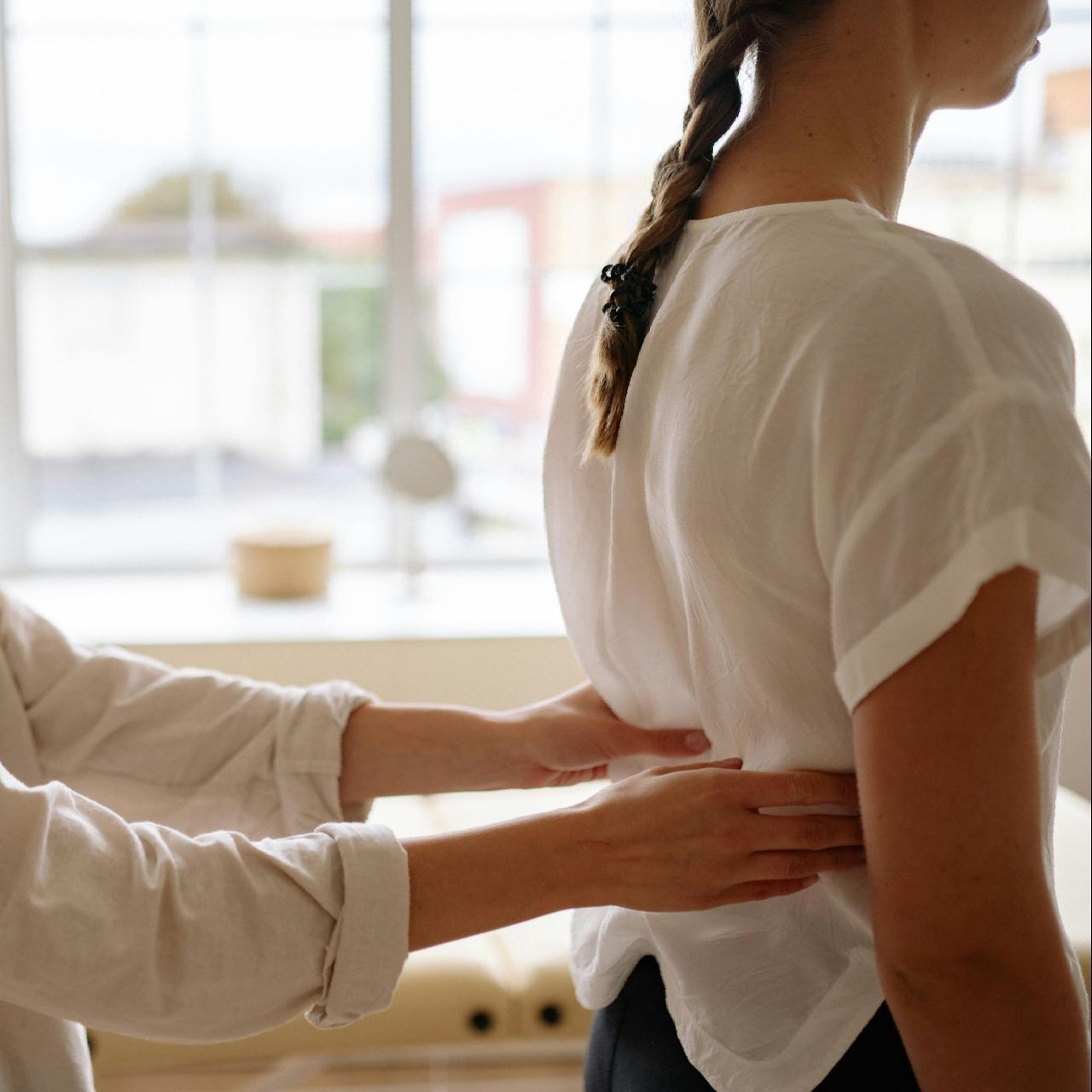 A woman is getting her back examined by a doctor