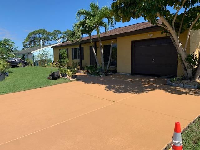 A house with a garage and a driveway in front of it.