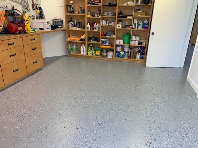 A room with a lot of shelves and a gray floor