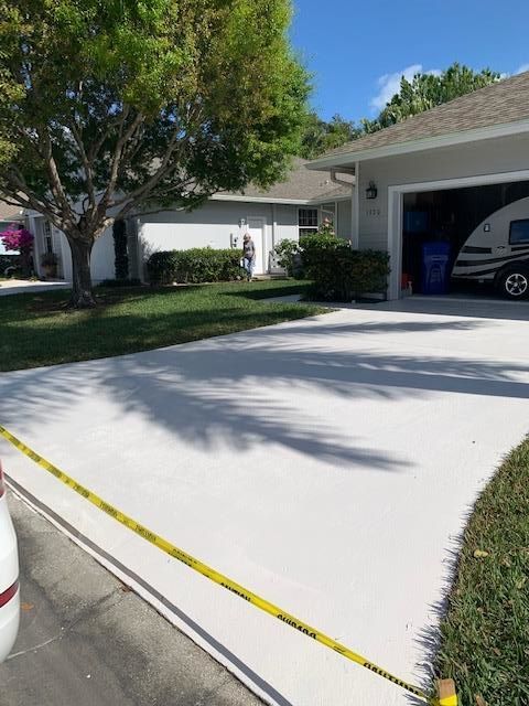 A car is parked in a driveway in front of a house