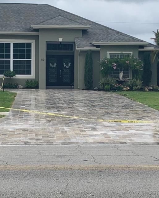 A large house with a brick driveway in front of it.