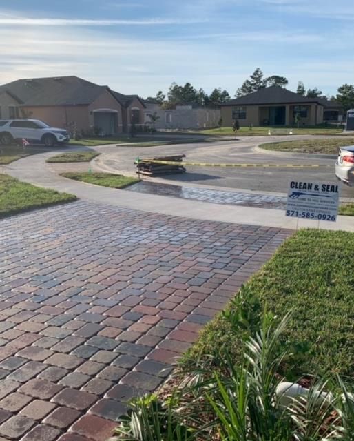 A brick driveway with a sign that says clean & seal