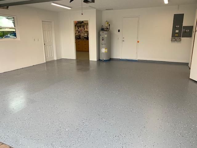 A garage with a gray floor and white walls.