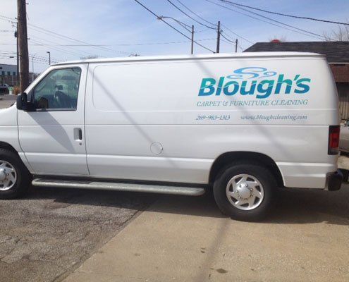 A white blough 's van is parked on the side of the road