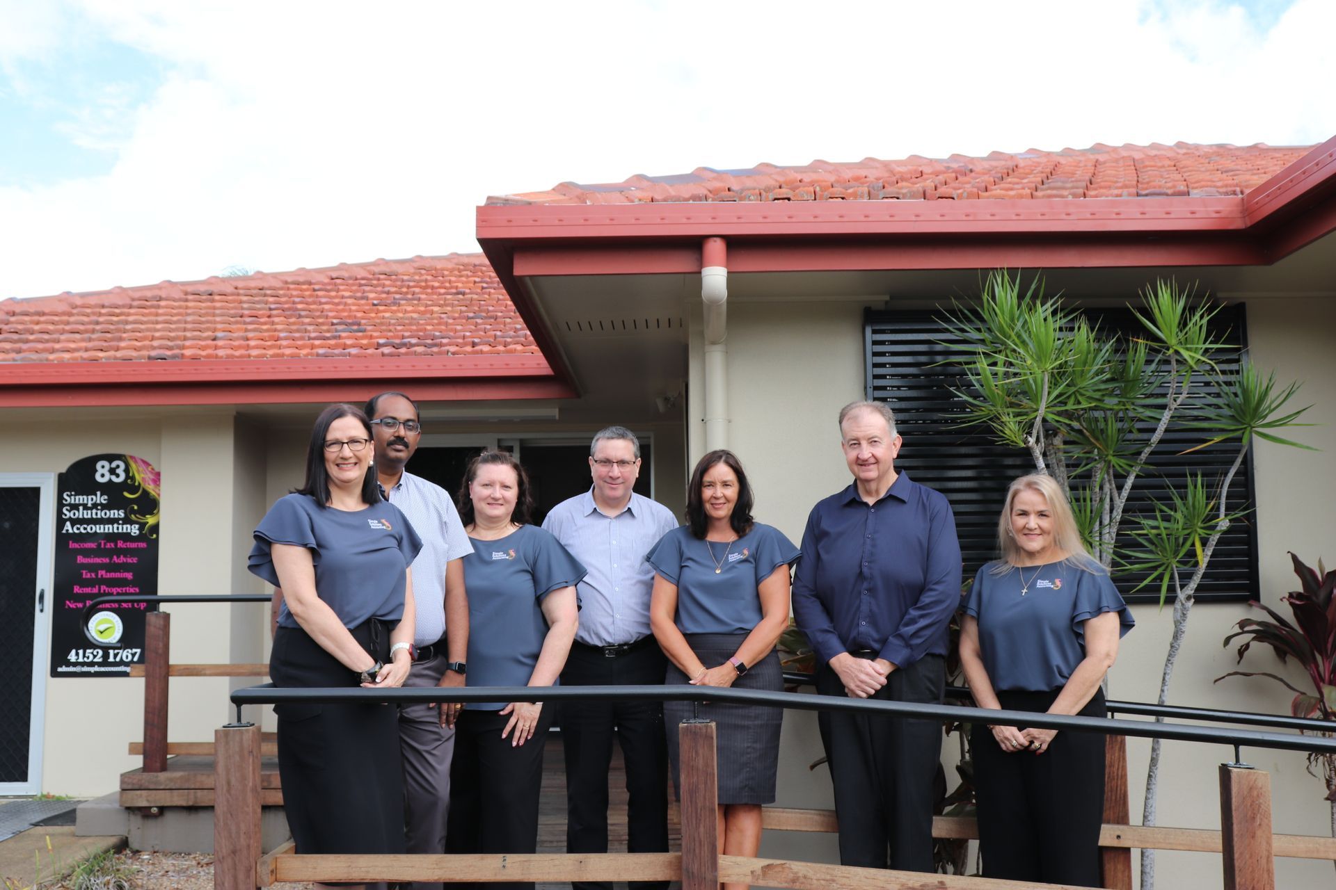 A Group Of People Are Standing In Front Of A Building — Simple Solutions Accounting In Bundaberg West, QLD