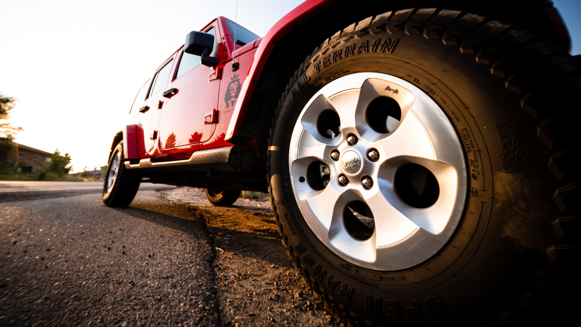 A red jeep is parked on the side of the road
