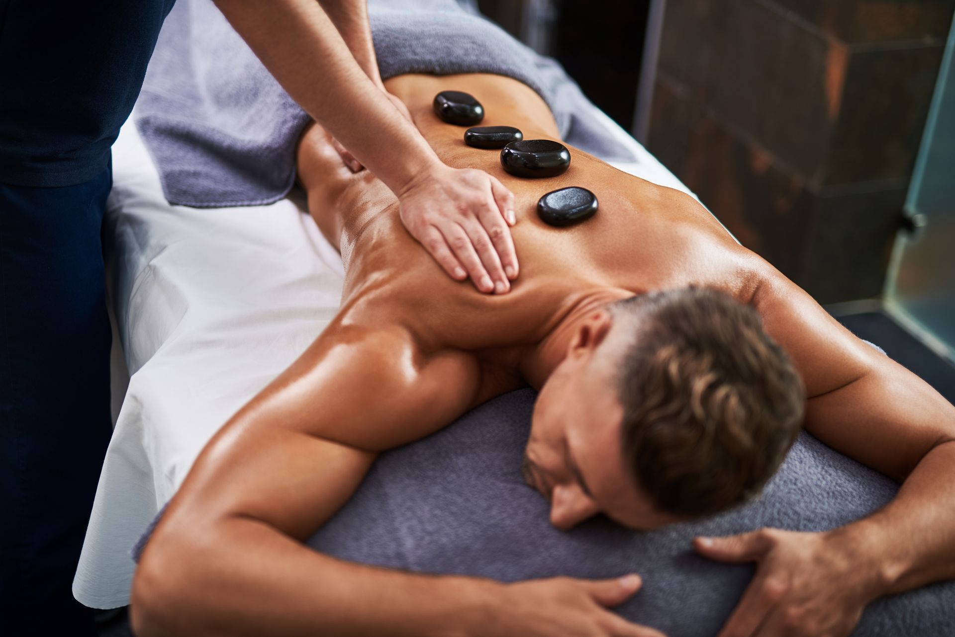 A man is getting a hot stone massage at a spa.