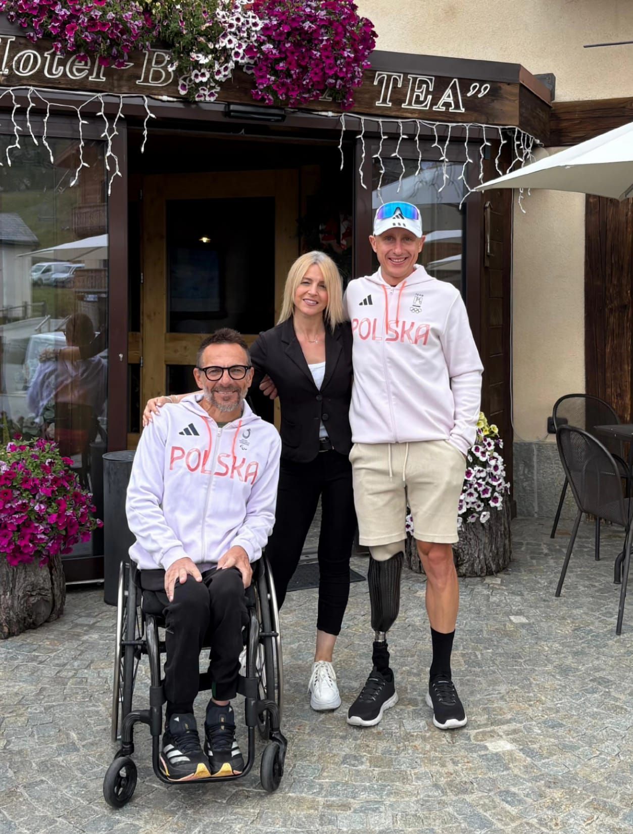 Tiramisù servito su un piatto bianco, ricoperto di cioccolato, su una tovaglia a quadretti rossi e bianchi.