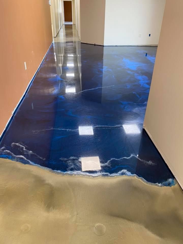 Blue and gold epoxy flooring in a hallway; the design resembles water meeting a sandy shore.