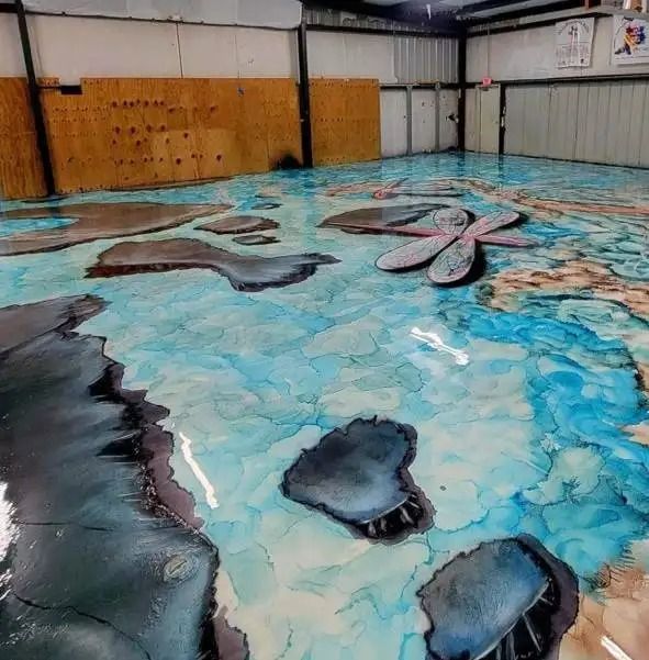 Epoxy floor art depicting a vivid ocean scene with blues, grays, and brown