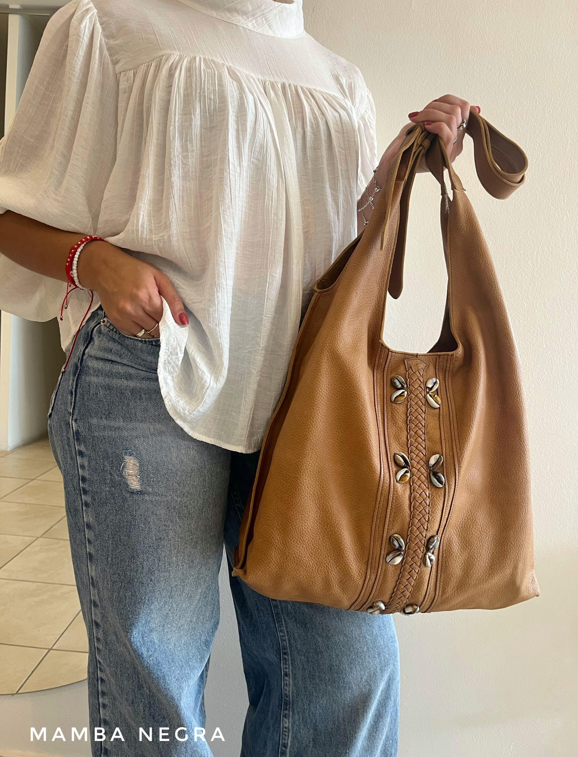 Un bolso estilo hobo holgado de gamuza color tostado con detalles de tachuelas plateadas