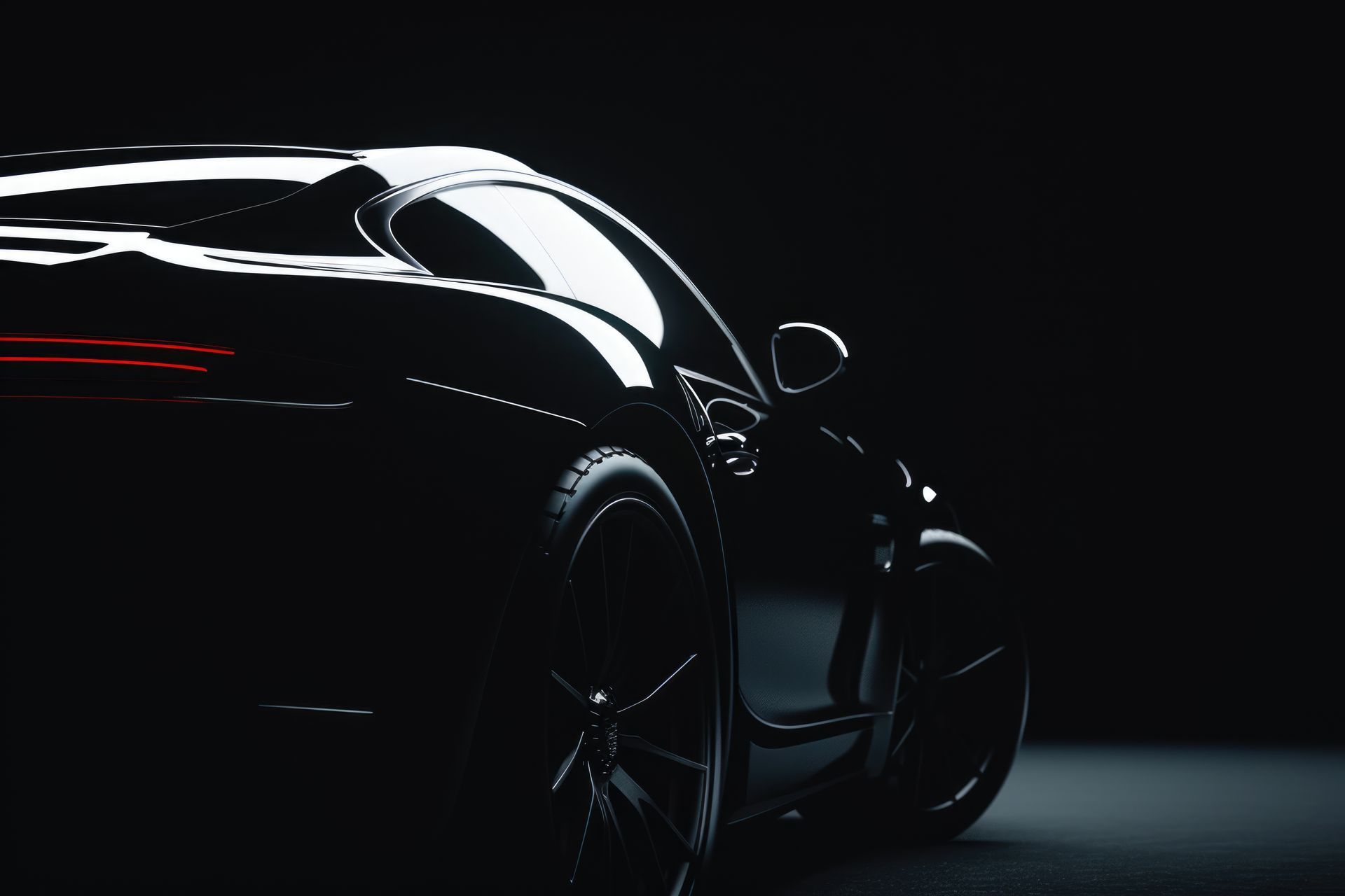 A sleek, black sports car emerges from the shadows, highlighted by rim lighting on its curved body and dark wheels.
