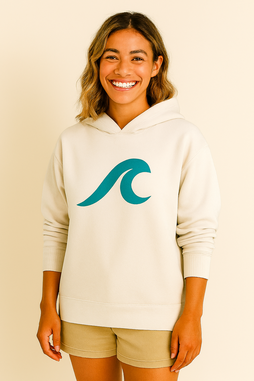 Mulher vestindo um moletom creme com um logotipo ondulado azul-petróleo, sorrindo.