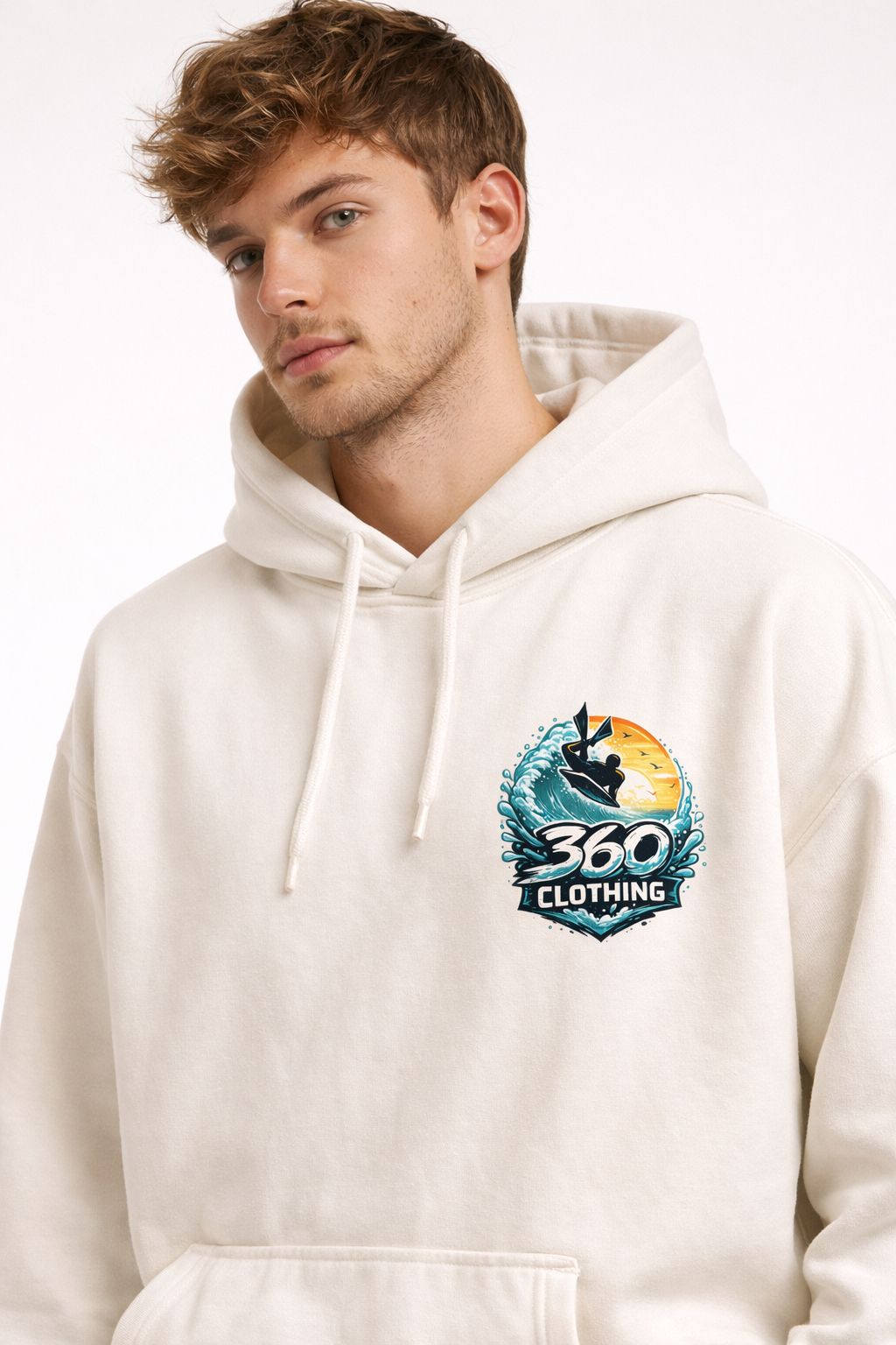 Homem vestindo moletom creme com estampa de surfe. O moletom tem capuz e é oversized.
