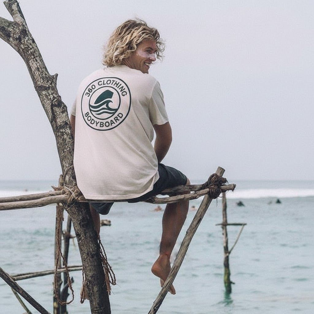 Homem de moletom cinza e shorts preto, em pé com as mãos ao lado do corpo, sobre fundo branco.