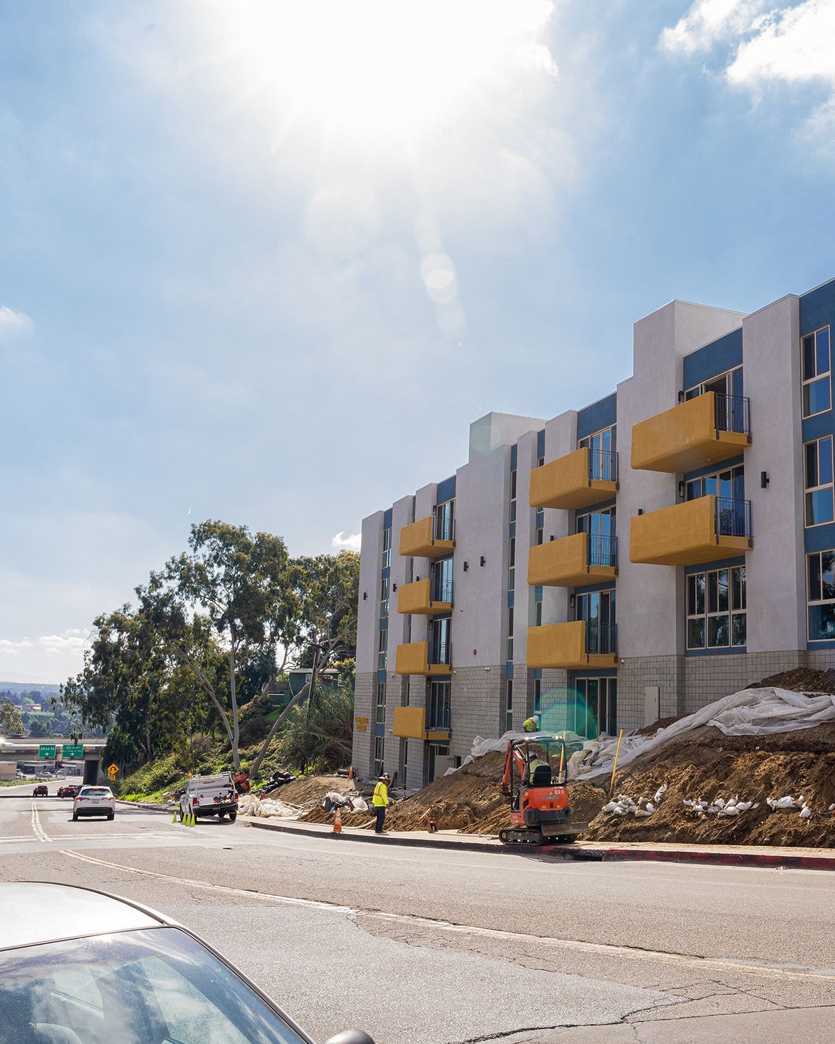 A car is parked in front of a building under construction