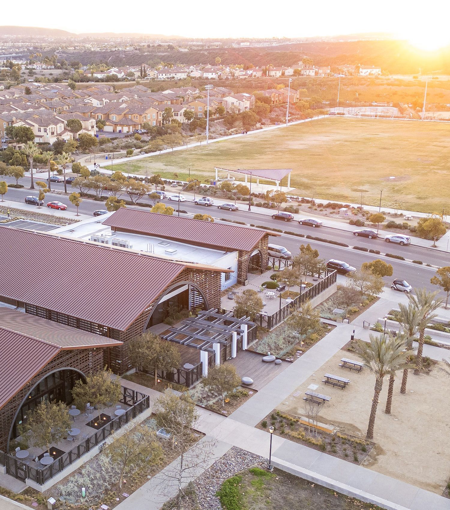 An aerial view of a city with a lot of buildings and a field in the background.