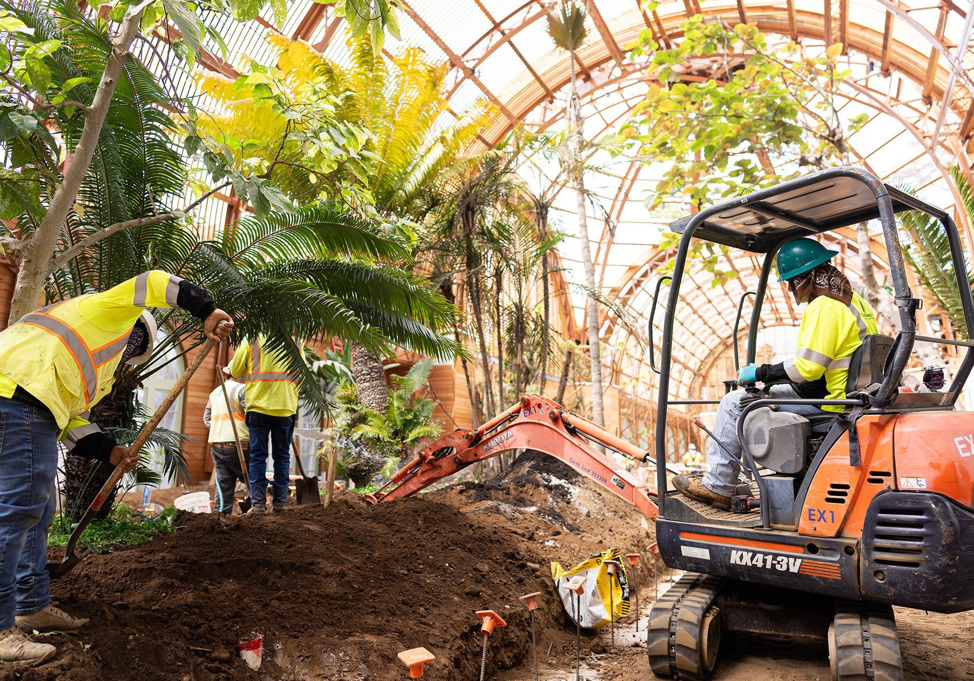 A group of construction workers are working in a greenhouse.