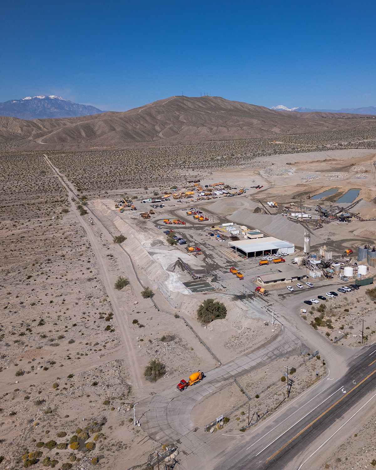 An aerial view of a desert landscape with mountains in the background.