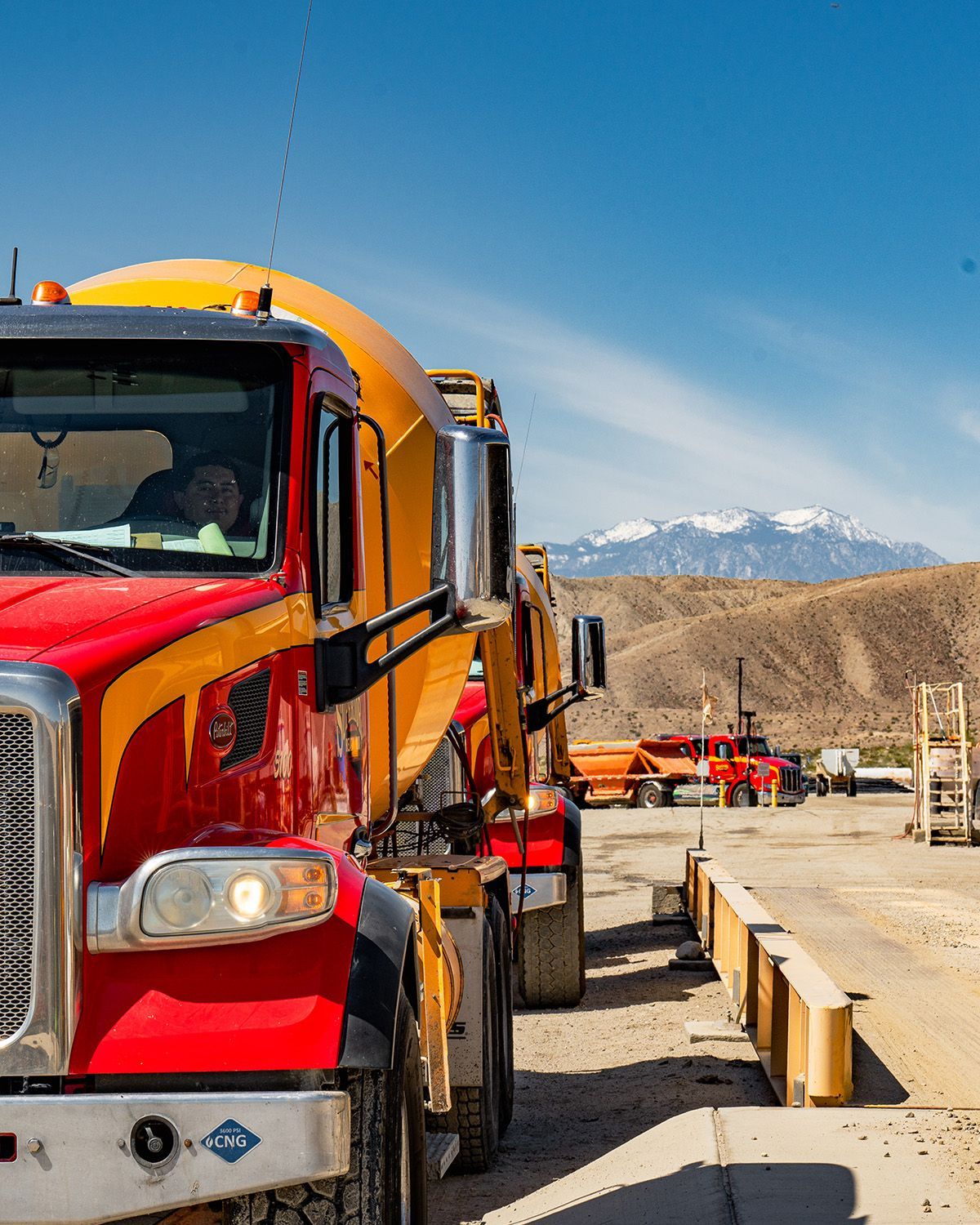 A red and yellow truck is parked on the side of the road.