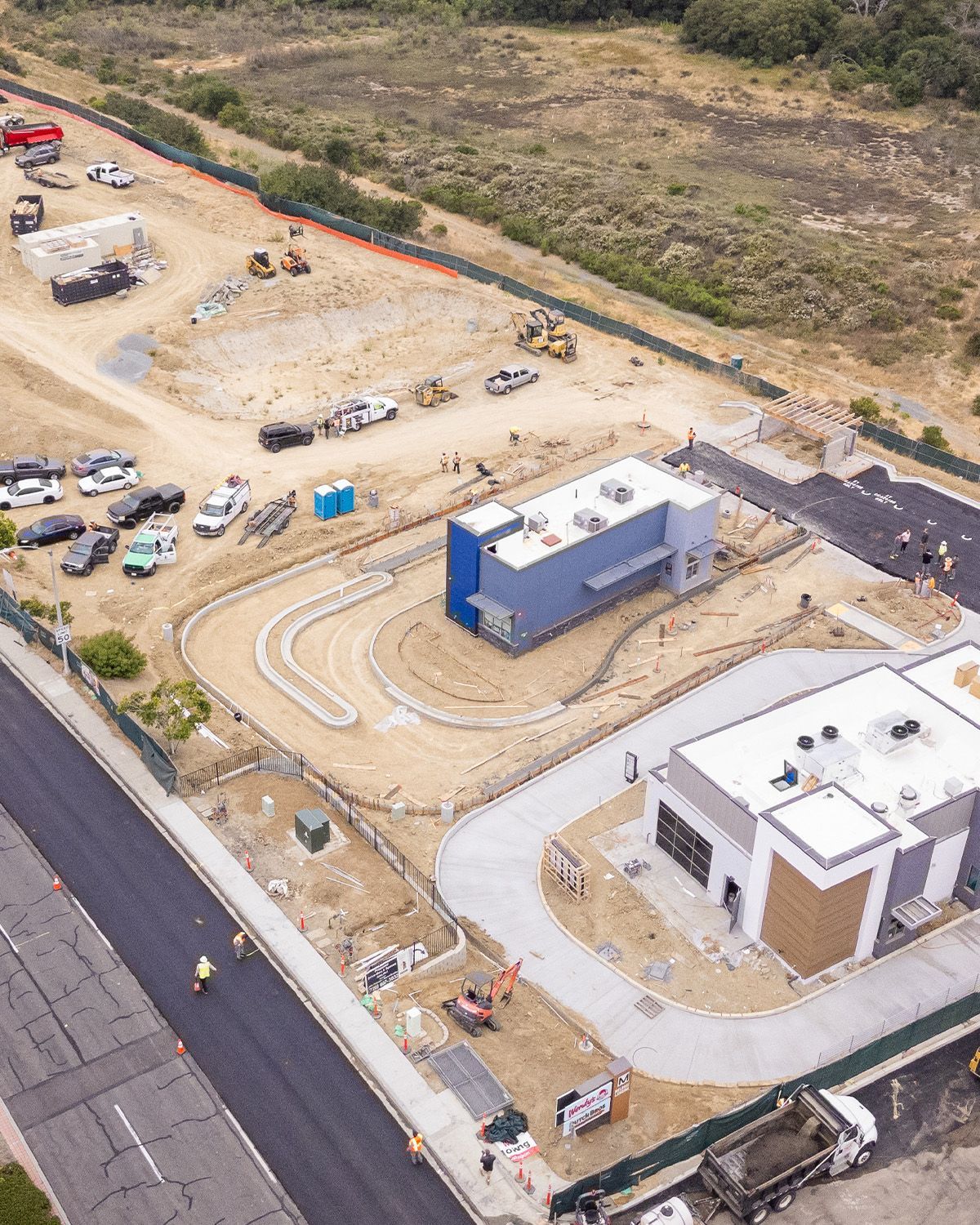 An aerial view of a construction site with a building in the middle of it.