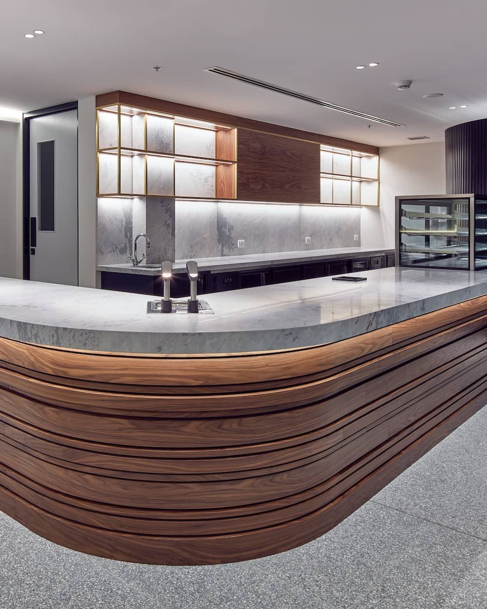 A Modern Kitchen Featuring a Sleek, Curved Countertop — Concept Kitchens In Port Macquarie, NSW